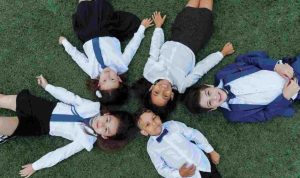Smiling students lying on the ground