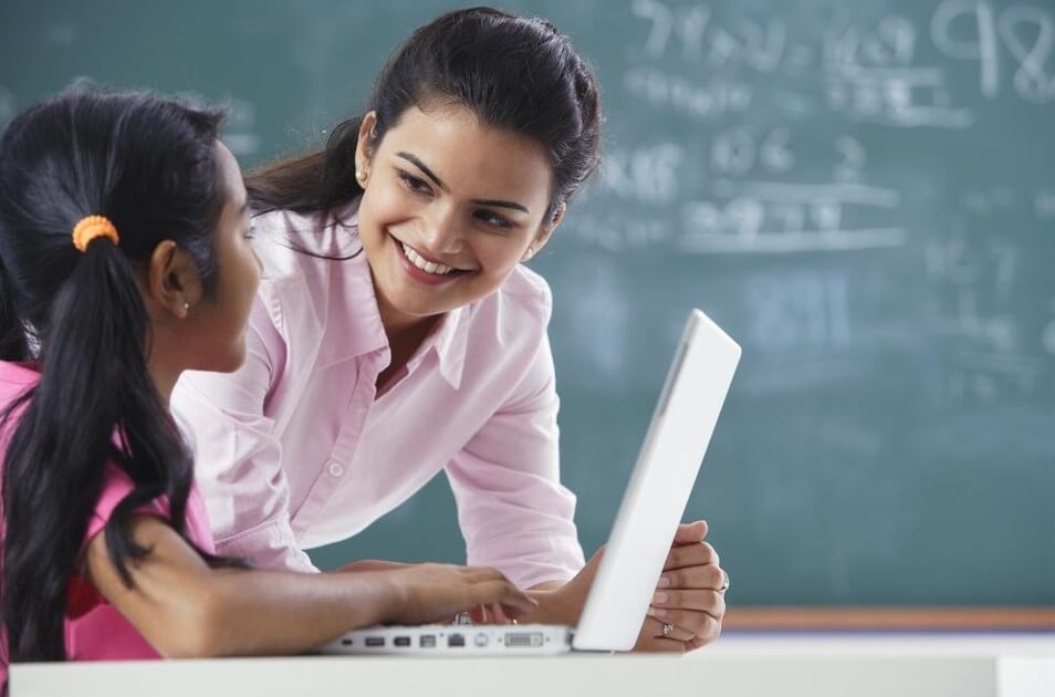 happy teacher with girl in school