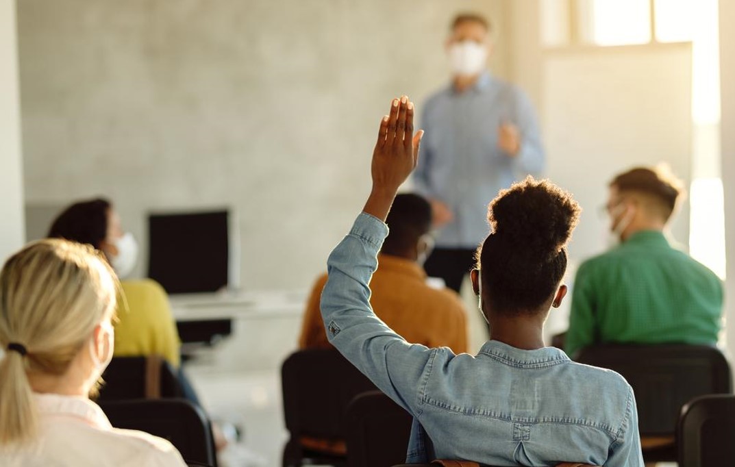 student raising hand for query in hand