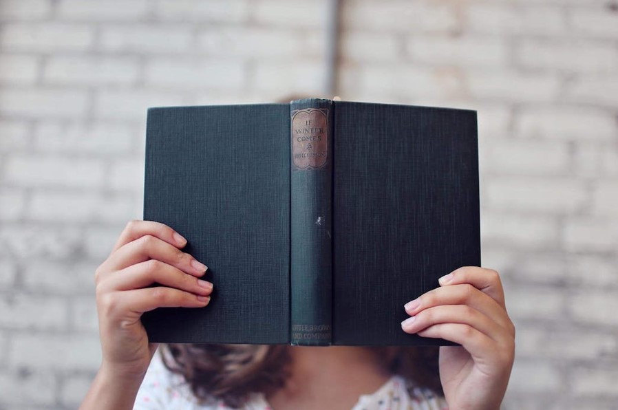 women with hidden face reading books