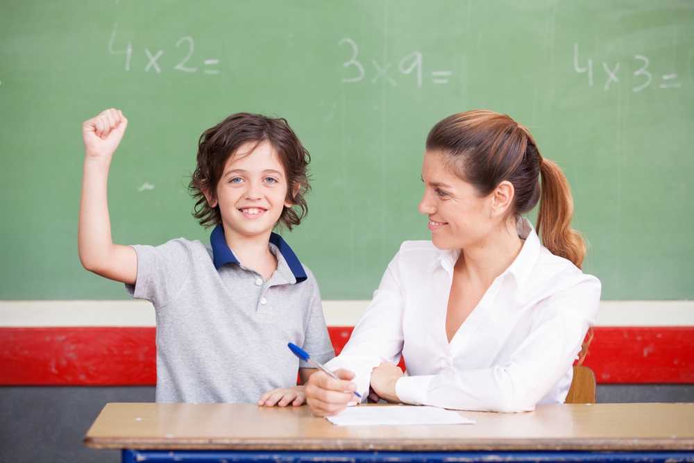 elementary student smiling after answering correctly to the teacher